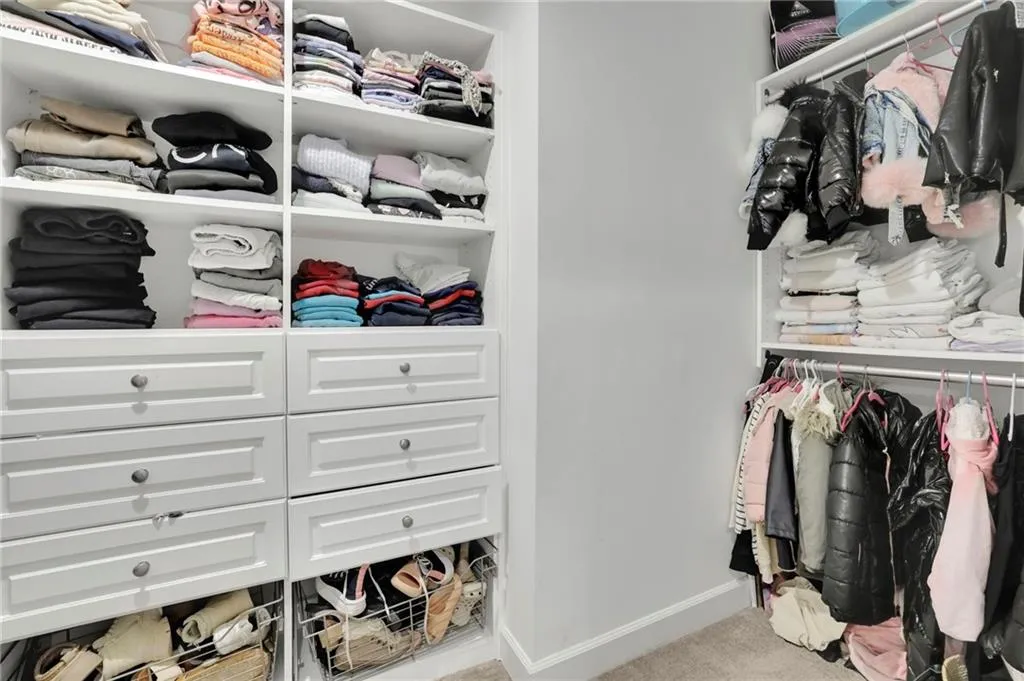 Walk in closet with light colored carpet