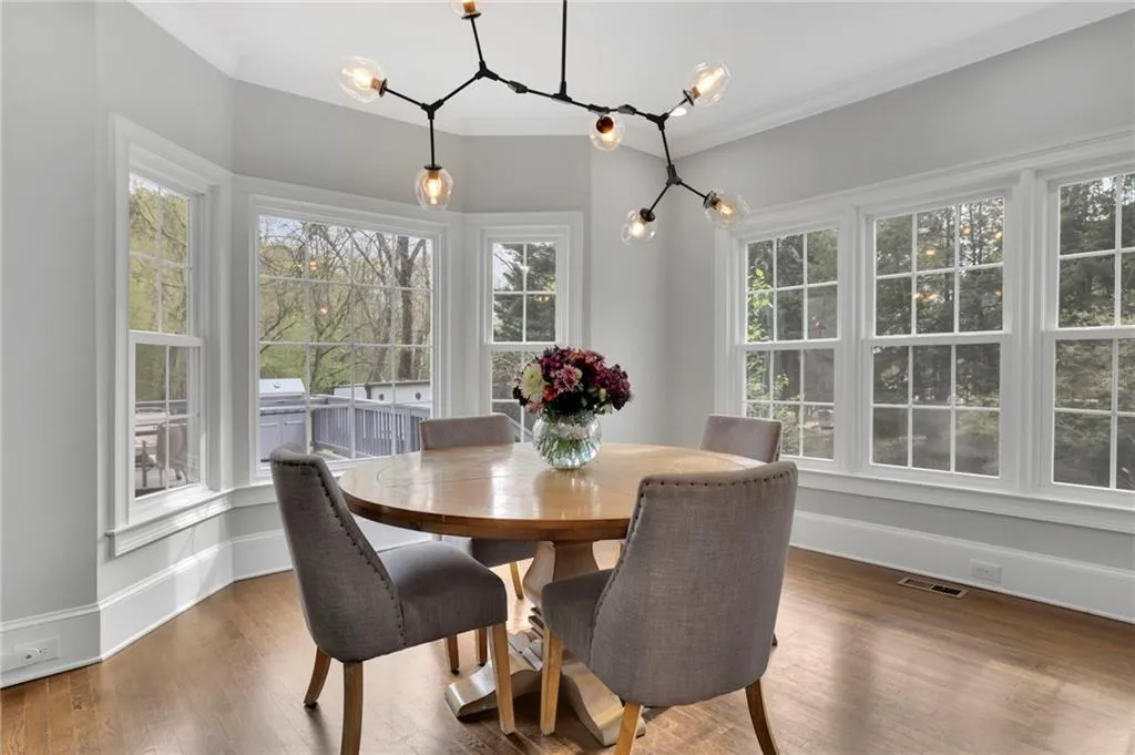 Dining space featuring wood finished floors and crown molding