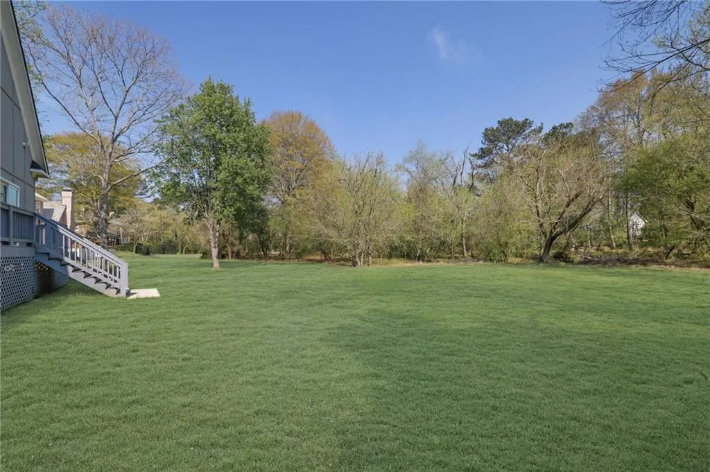 View of grassy yard featuring stairs