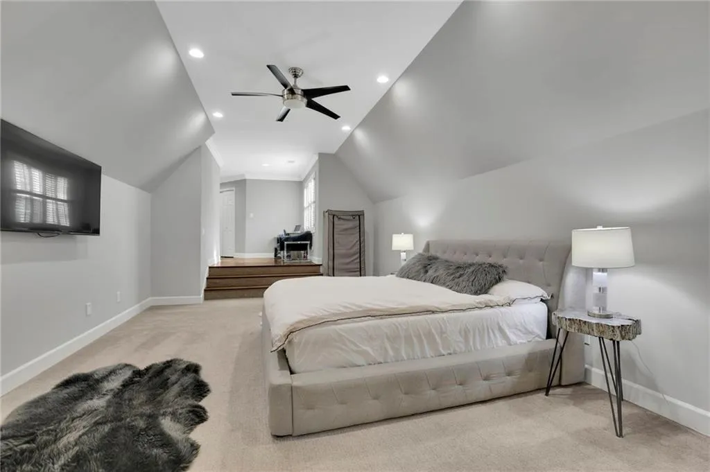 Bedroom with light colored carpet, recessed lighting, ceiling fan, and lofted ceiling