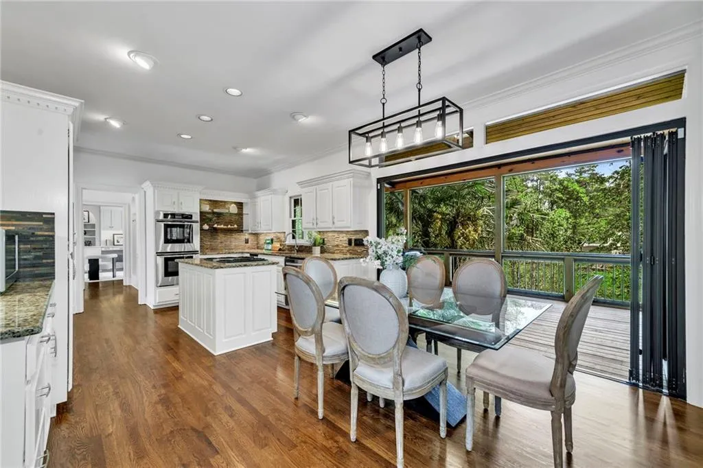 Dining space with dark wood-type flooring, a chandelier, and ornamental molding Dining space with dark wood-type flooring, a chandelier, and ornamental molding