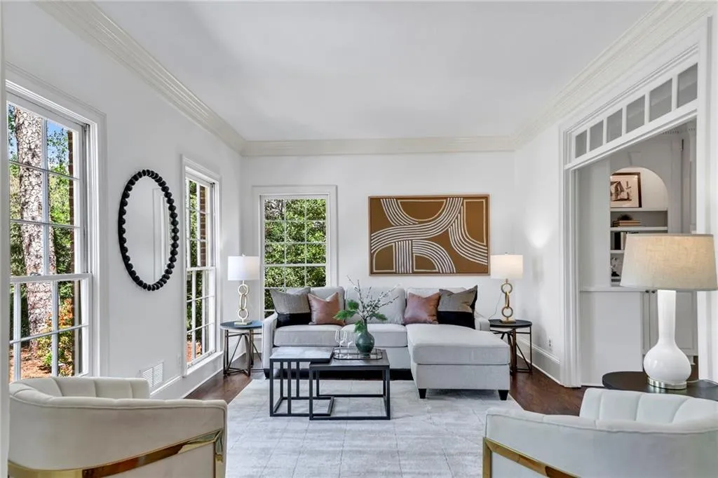 Living room with a healthy amount of sunlight, light hardwood / wood-style flooring, and crown molding Living room with a healthy amount of sunlight, light hardwood / wood-style flooring, and crown molding
