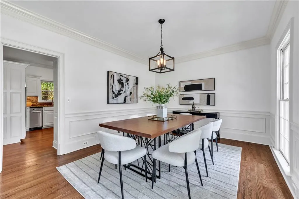 Dining area with a notable chandelier, hardwood / wood-style flooring, and ornamental molding Dining area with a notable chandelier, hardwood / wood-style flooring, and ornamental molding