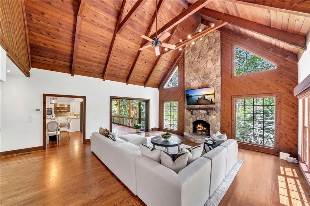 Living room featuring high vaulted ceiling, wooden ceiling, light hardwood / wood-style floors, and a fireplace Living room featuring high vaulted ceiling, wooden ceiling, light hardwood / wood-style floors, and a fireplace