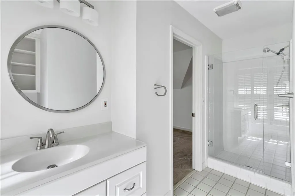 Bathroom featuring walk-in frameless shower, tile floors, and vanity Bathroom featuring walk-in frameless shower, tile floors, and vanity