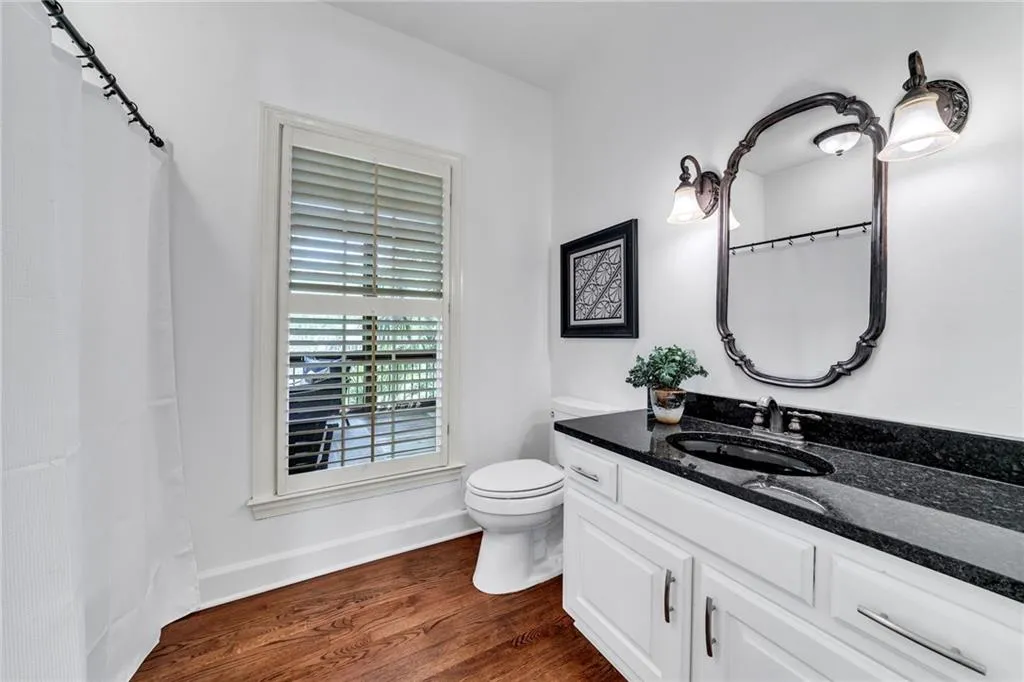 Bathroom featuring wood-type flooring, vanity, and toilet Bathroom featuring wood-type flooring, vanity, and toilet