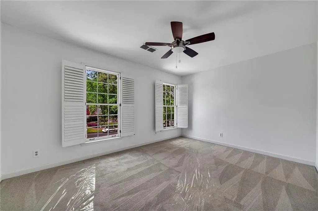 Bedroom 3 featuring light colored carpet, closet with built-ins and ceiling fan Bedroom 3 featuring light colored carpet, closet with built-ins and ceiling fan