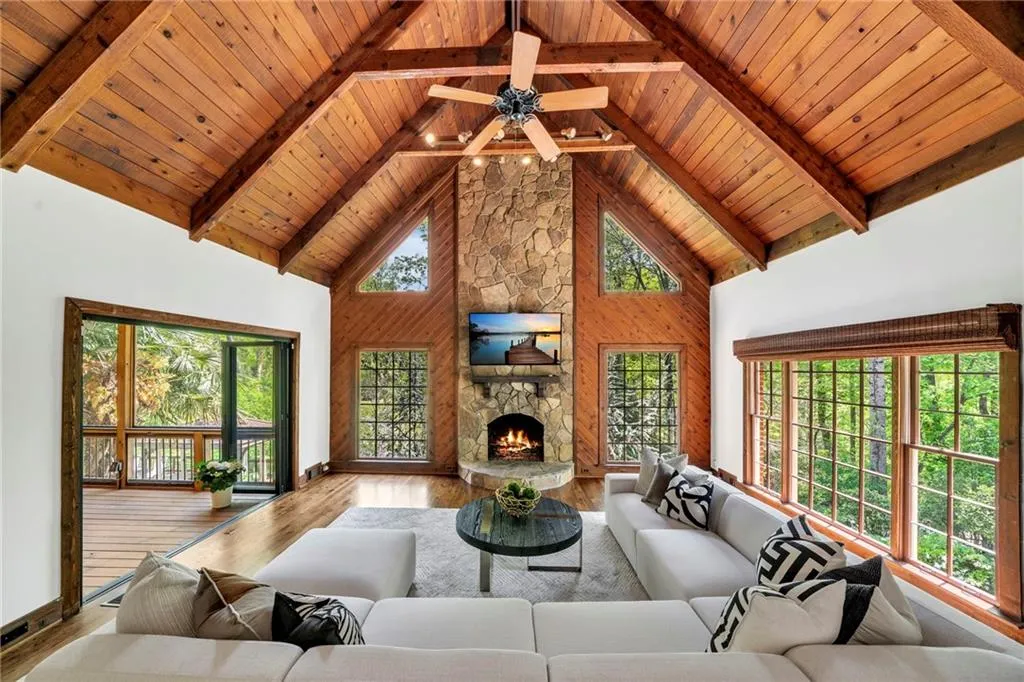 Unfurnished living room featuring high vaulted ceiling, a stone fireplace, light hardwood / wood-style floors, beam ceiling, and wooden ceiling Unfurnished living room featuring high vaulted ceiling, a stone fireplace, light hardwood / wood-style floors, beam ceiling, and wooden ceiling