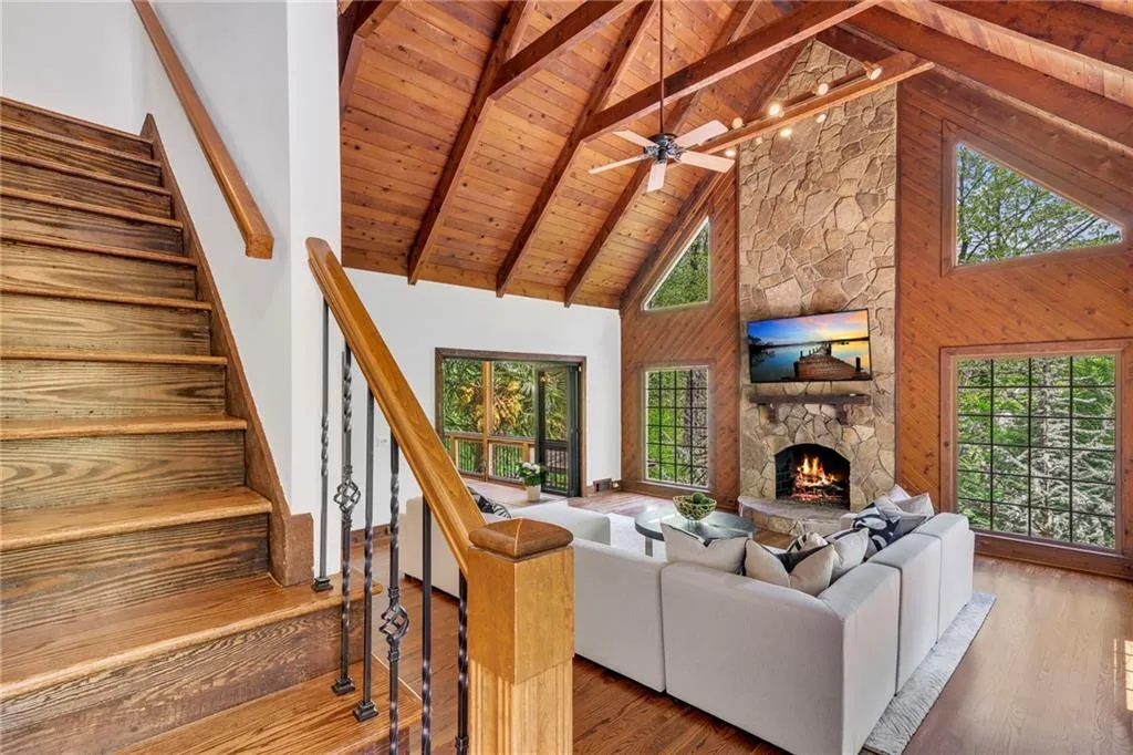 Unfurnished living room featuring dark hardwood / wood-style flooring, beam ceiling, and a healthy amount of sunlight Unfurnished living room featuring dark hardwood / wood-style flooring, beam ceiling, and a healthy amount of sunlight