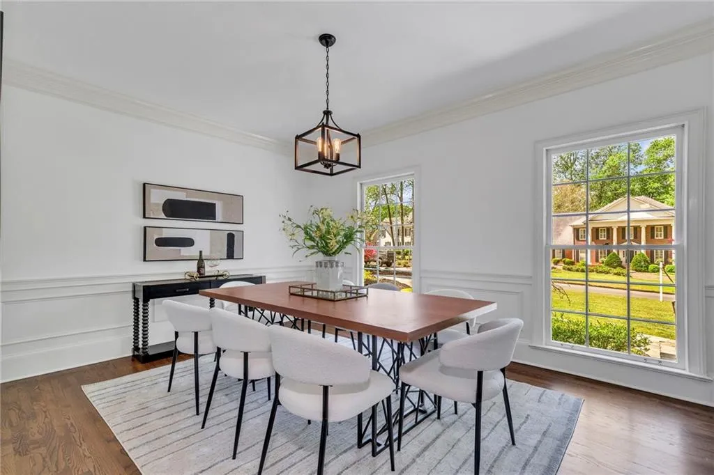 Dining space featuring a healthy amount of sunlight, dark wood-type flooring, and crown molding Dining space featuring a healthy amount of sunlight, dark wood-type flooring, and crown molding