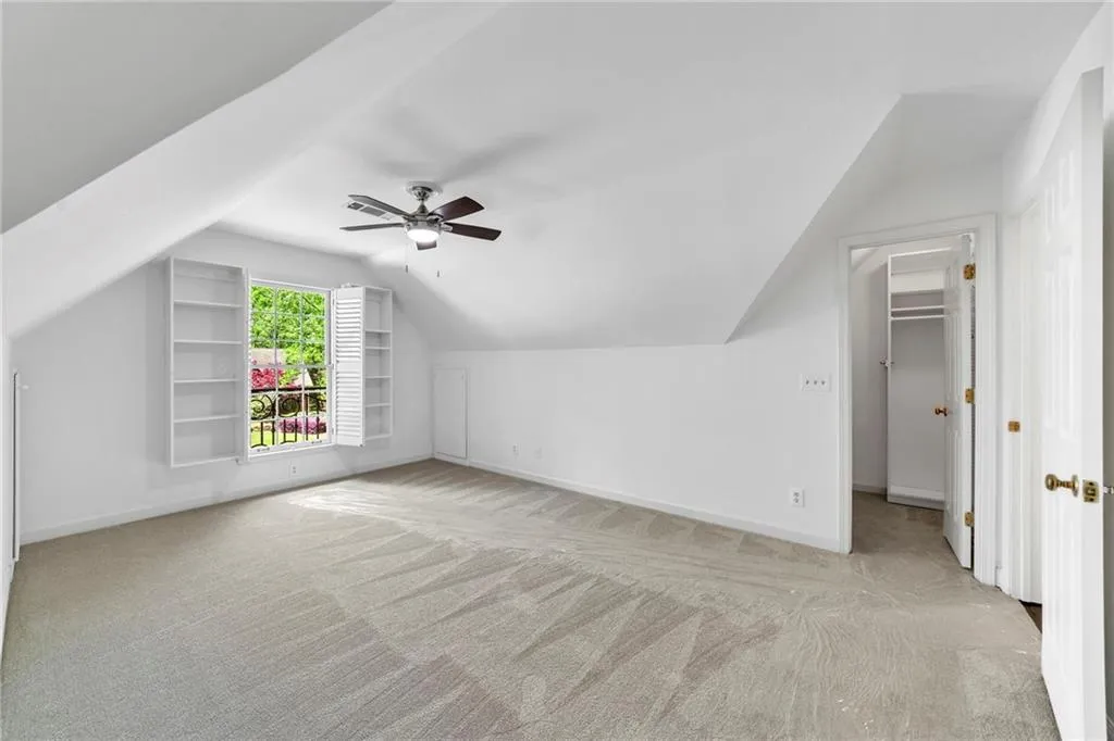 Bedroom 4 with lofted ceiling, adjoining full bath, ceiling fan, and light carpet, and closet with built-ins Bedroom 4 with lofted ceiling, adjoining full bath, ceiling fan, and light carpet, and closet with built-ins