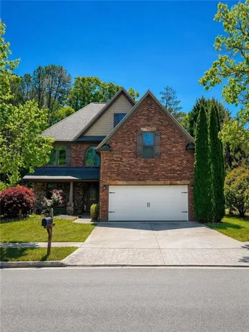 Brick and siding exterior featuring a two-car garage with carriage-style doors