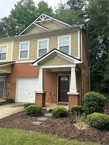 View of front of home featuring brick siding, driveway, a porch, and an attached garage