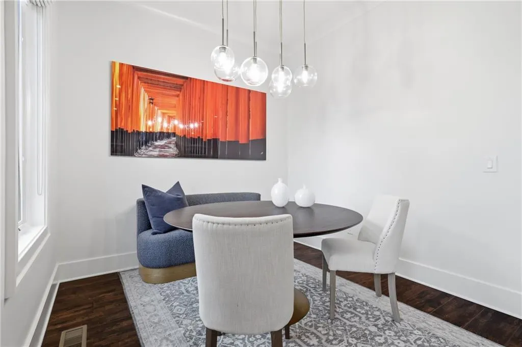 Dining area featuring wood-finish flooring, white baseboards, and a contemporary multi-pendant light fixture