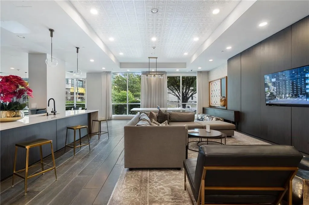 Living area with hardwood / wood-style floors, a tray ceiling, and recessed lighting