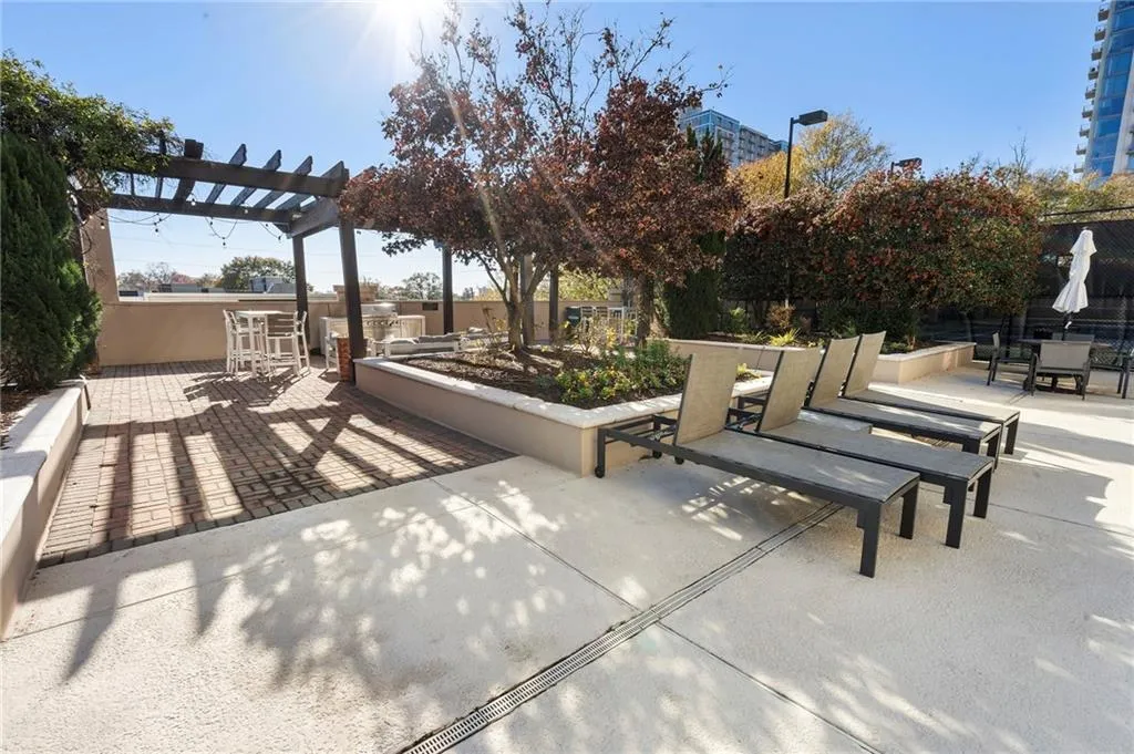 View of patio / terrace featuring a pergola, outdoor dining area, and a garden