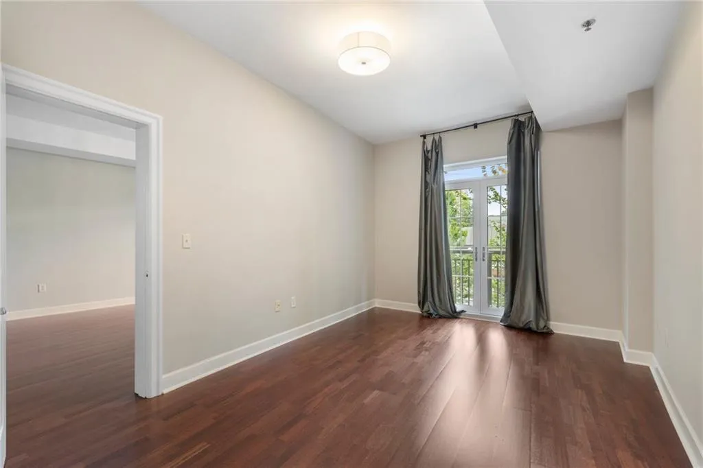 Empty room featuring dark wood-style floors and baseboards