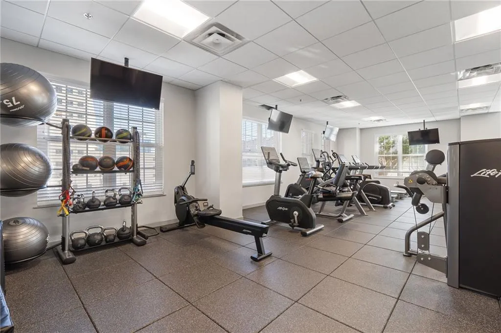 Gym featuring healthy amount of natural light and a paneled ceiling