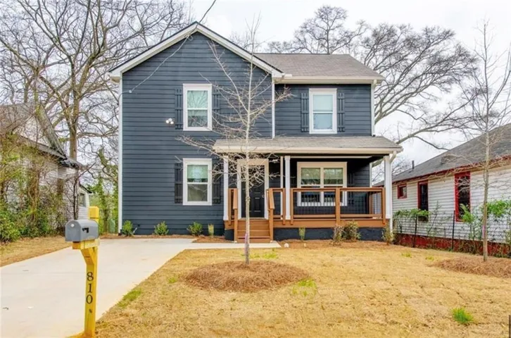 Two-story residence featuring dark siding and white trim