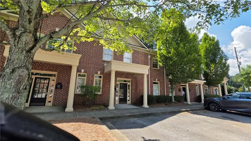 Brick exterior with white columned porticos and dark-framed windows