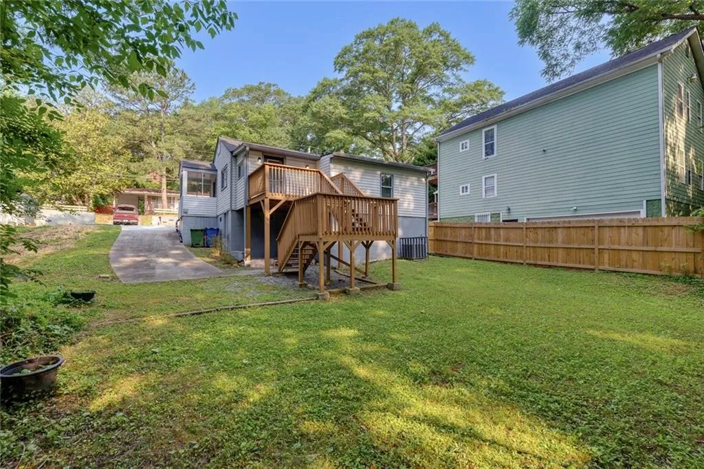 Back of property featuring a deck, stairs, and a patio area