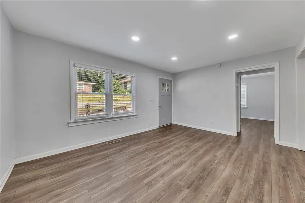 Empty room with wood finished floors, baseboards, and recessed lighting