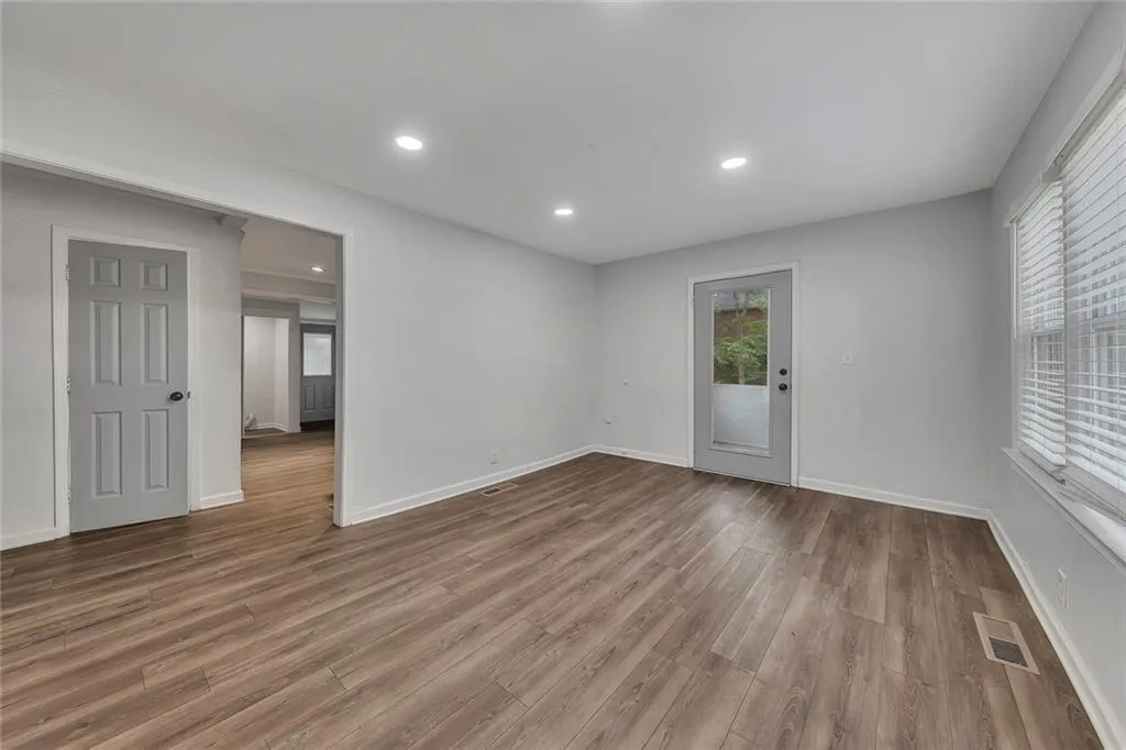 Empty room with wood finished floors, baseboards, and recessed lighting