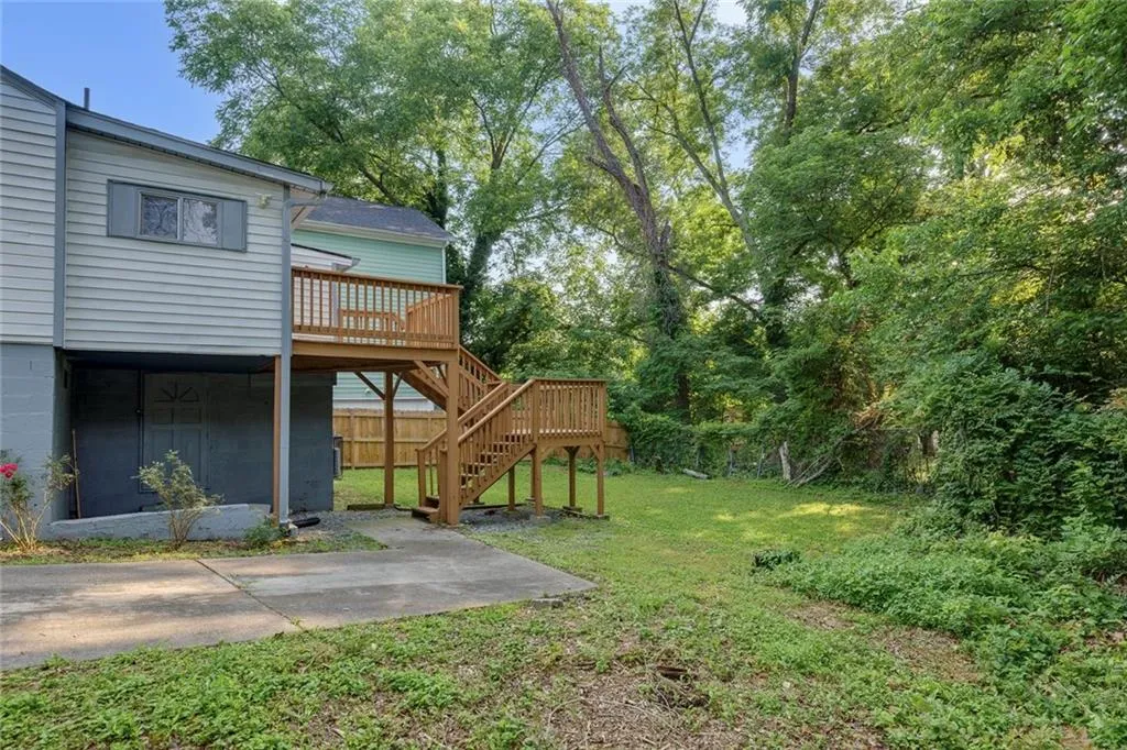 View of yard featuring stairs, a wooden deck, and a patio area