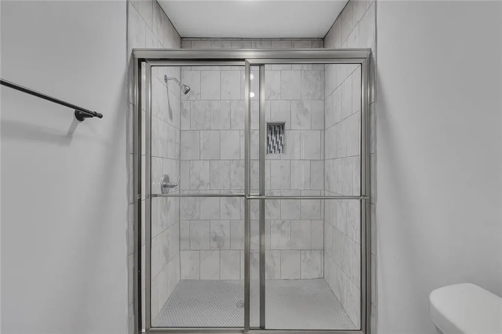 Full bathroom with toilet and a shower stall