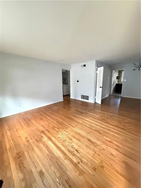 Refinished wood-finish flooring provides a warm aesthetic to this spacious interior