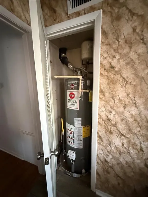 Dedicated utility closet housing a water heater with associated plumbing and a pressure expansion tank