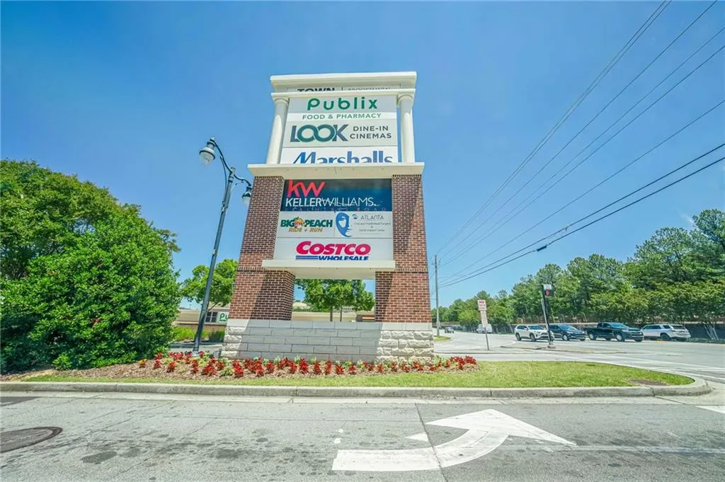 Multi-tenant pylon sign featuring brick and stone construction with multiple retail and service tenants