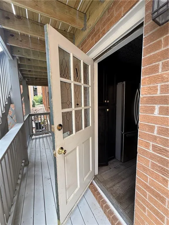Entry door with decorative glass inserts opening to a wood-finish flooring interior