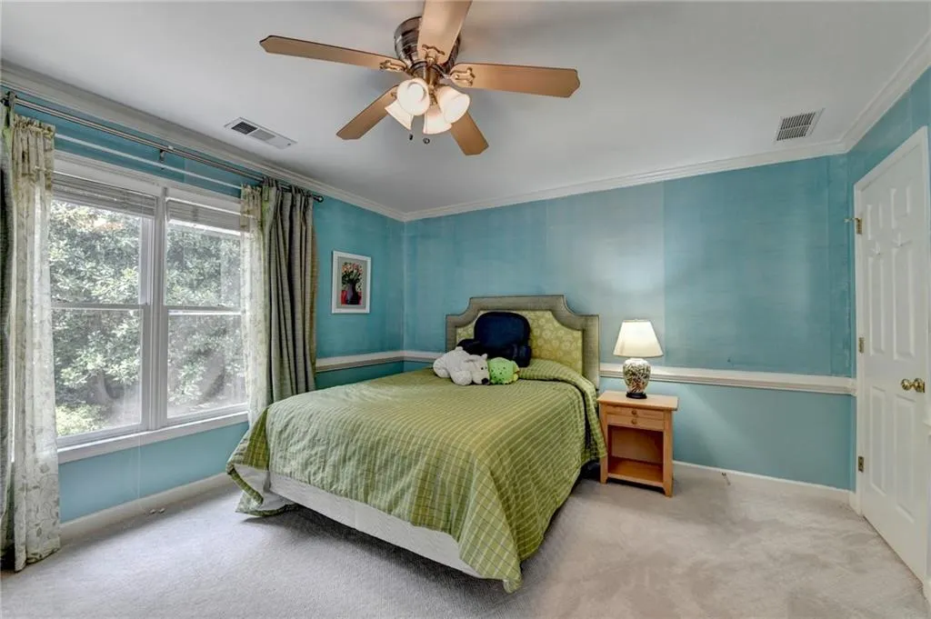 Bedroom with crown molding, carpet, and ceiling fan