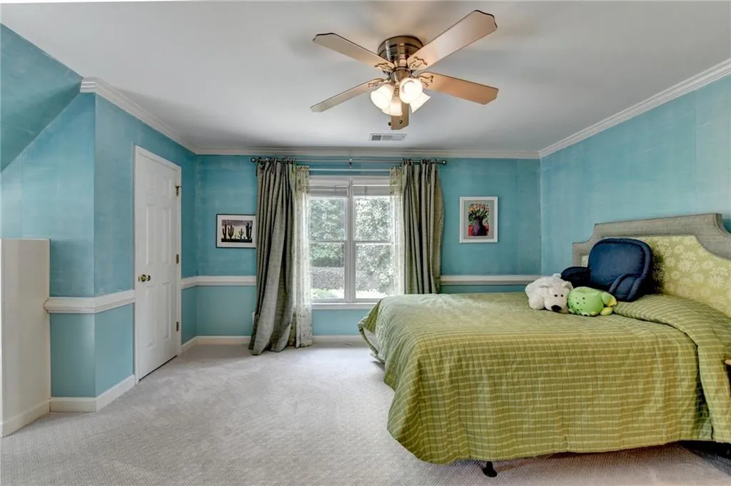 Bedroom featuring crown molding, carpet, and a ceiling fan