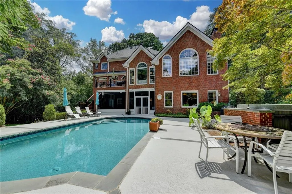 Swimming pool with a patio, a balcony, and a sunroom