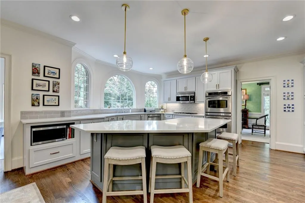 Kitchen featuring backsplash, healthy amount of natural light, a breakfast bar, crown molding, and recessed lighting