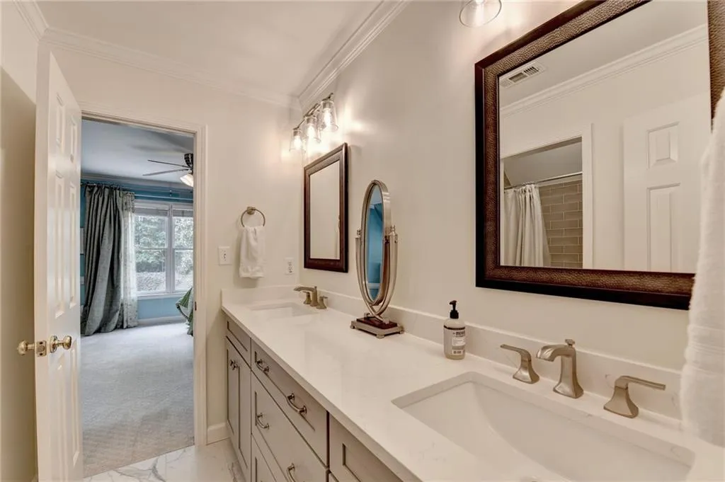 Full bathroom featuring ornamental molding, double vanity, a shower with curtain, and a ceiling fan