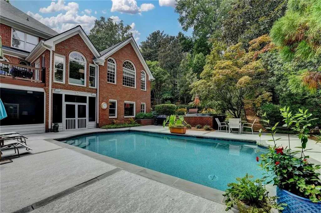 Outdoor pool with a patio and a sunroom