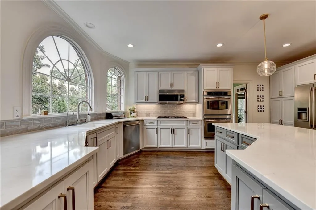 Kitchen with decorative backsplash, plenty of natural light, stainless steel appliances, light stone counters, and recessed lighting