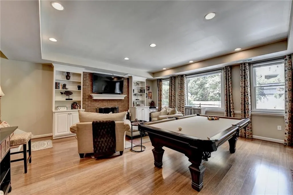 Playroom featuring a brick fireplace, recessed lighting, pool table, a tray ceiling, and light wood finished floors