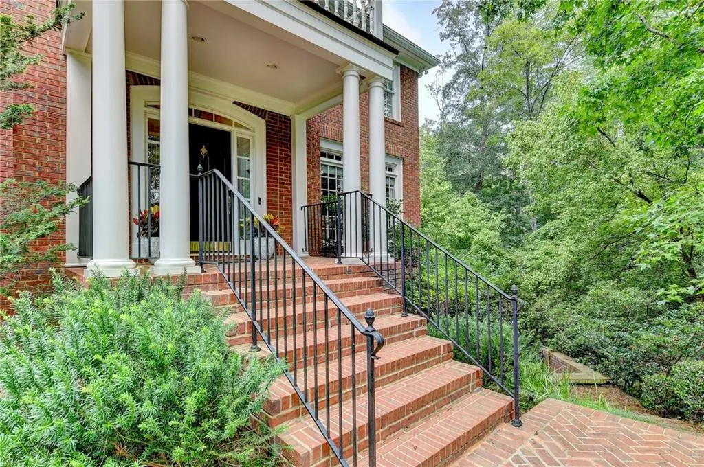 View of exterior entry with brick siding and covered porch