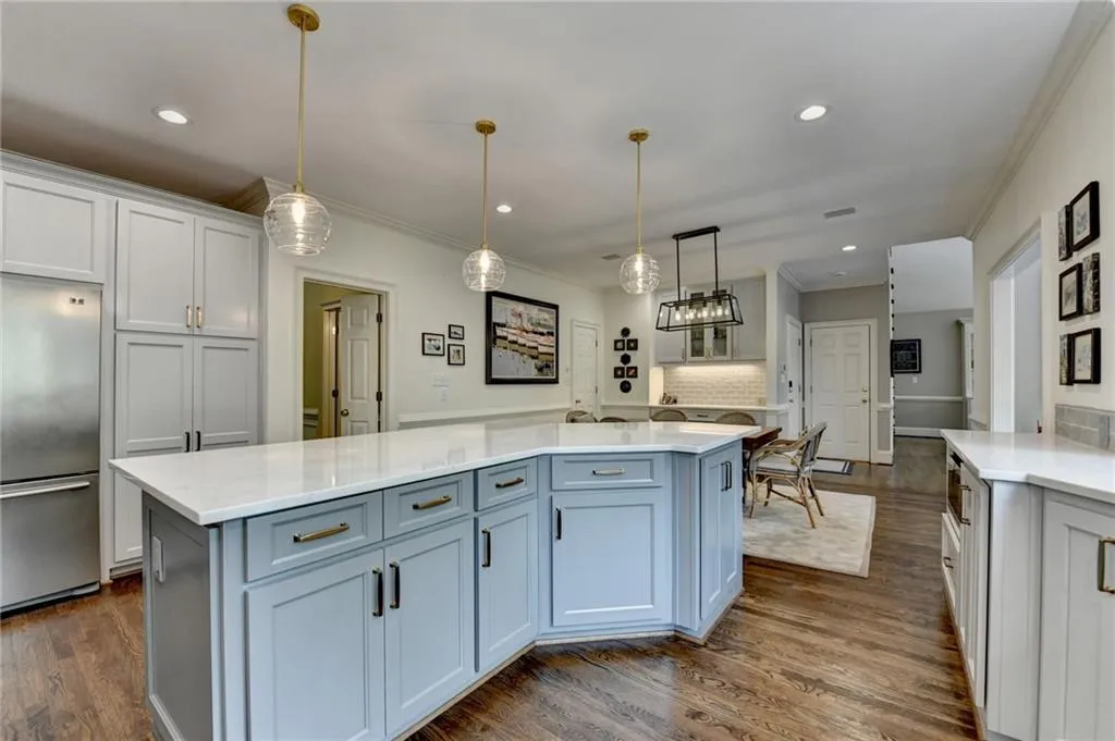Kitchen featuring stainless steel refrigerator, tasteful backsplash, a kitchen island, white cabinetry, and recessed lighting