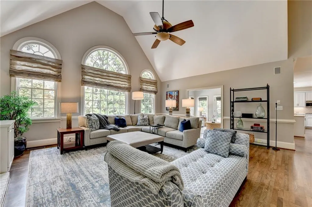 Living area featuring high vaulted ceiling, ceiling fan, and wood finished floors