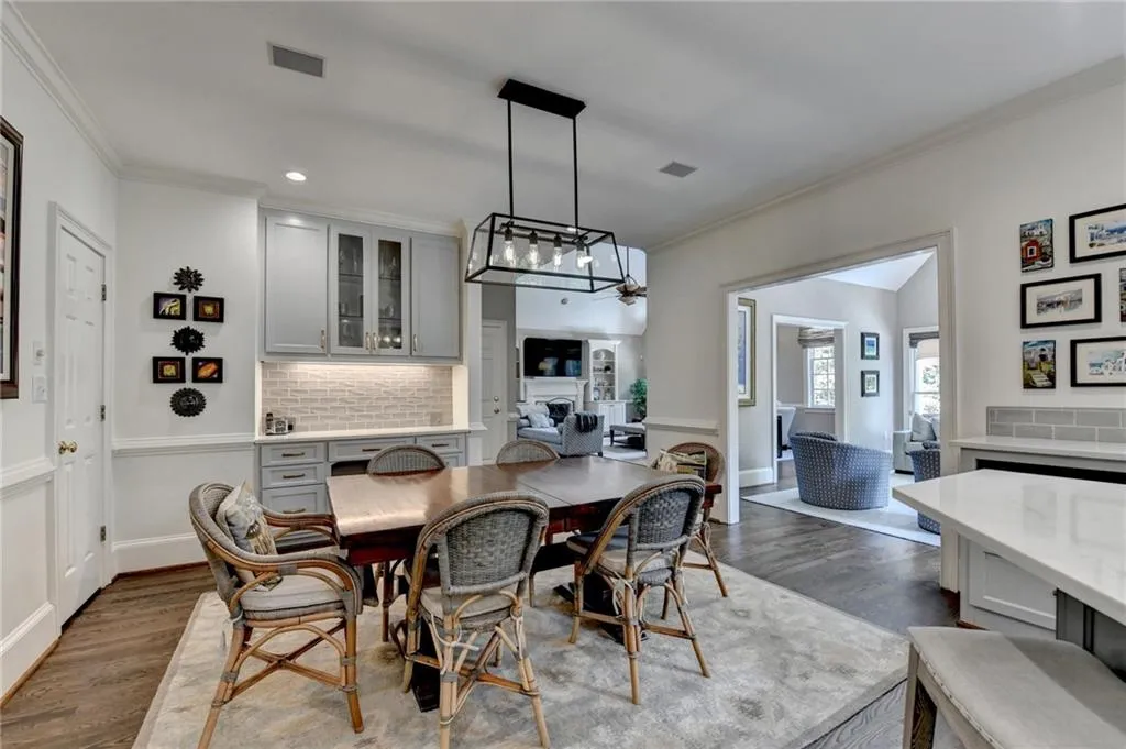 Dining space with crown molding, dark wood-type flooring, and recessed lighting
