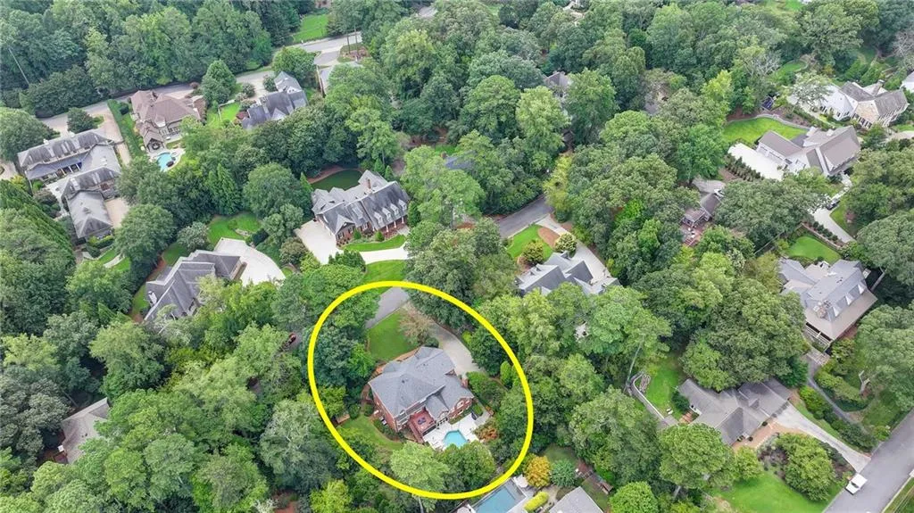 Aerial overview of property's location with nearby suburban area and a tree filled landscape
