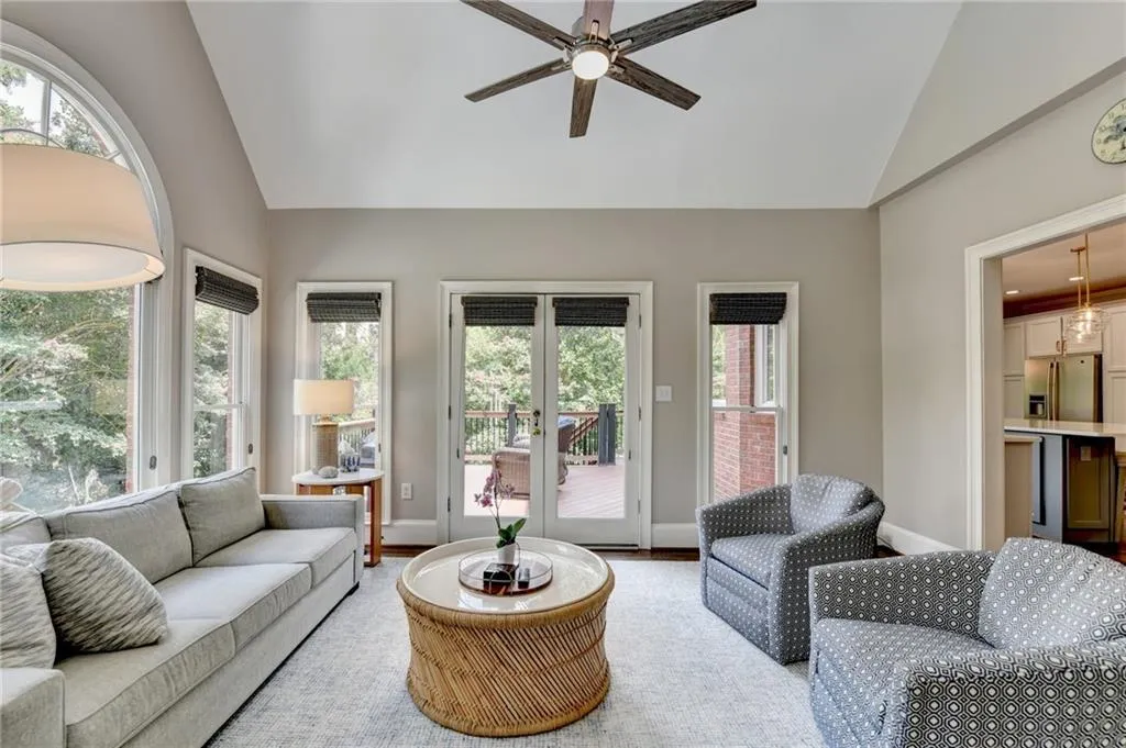 Living room featuring high vaulted ceiling, healthy amount of natural light, a ceiling fan, and wood finished floors