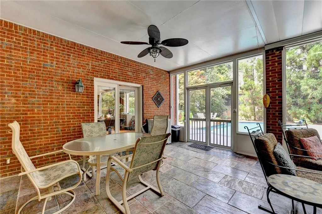 Sunroom with ceiling fan and outdoor dining space
