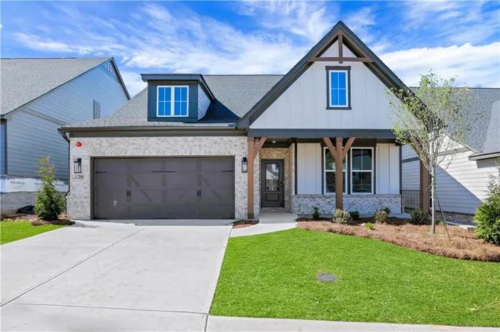 Craftsman-style facade featuring board and batten siding, stone accents, and exposed timber details