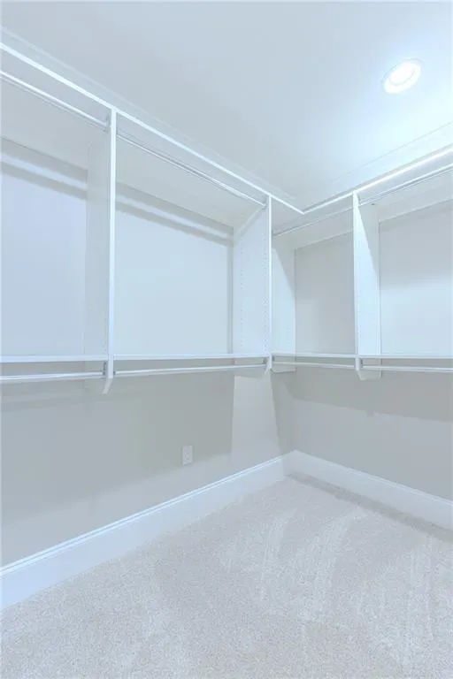 Walk in closet featuring light carpet